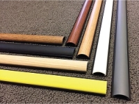 variety of chordsaver cord cover colors laid out on carpet floor.