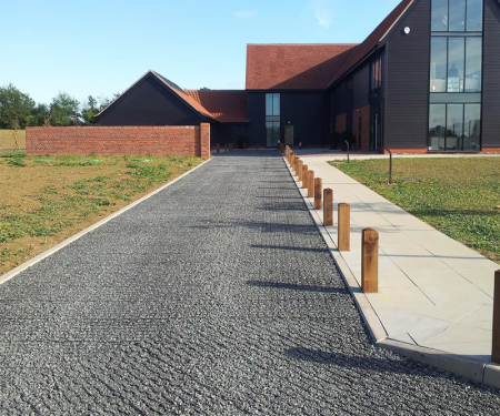 Geogrid permeable paving tile in use with gravel for completed home driveway Geogrid permeable paving tile in use with gravel for completed home driveway