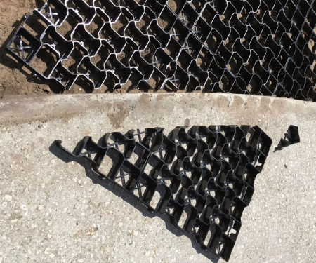 Geogrid permeable paving tile being cut to match planned landscaping Geogrid permeable paving tile being cut to match planned landscaping