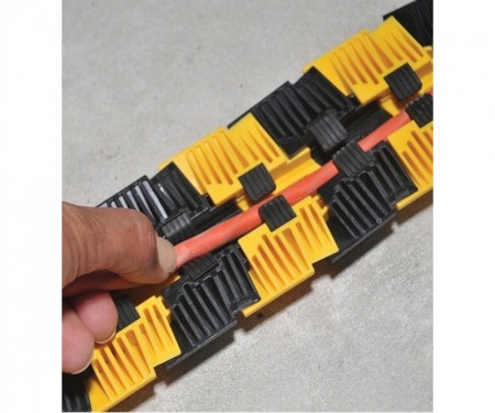 Cords being inserted in Sidewinder floor cord cover